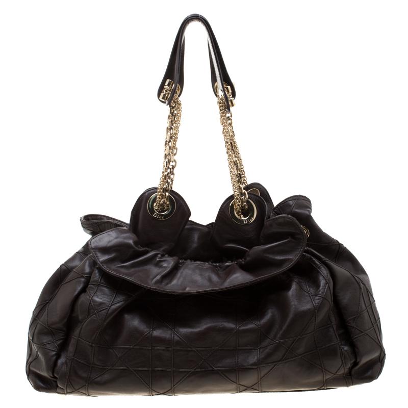 This stylish Le Trente hobo from Dior has been crafted from brown leather and styled with their signature cannage pattern. The bag features dual chain handles with leather shoulder rest, a CD cutout charm, a drawstring closure and protective metal