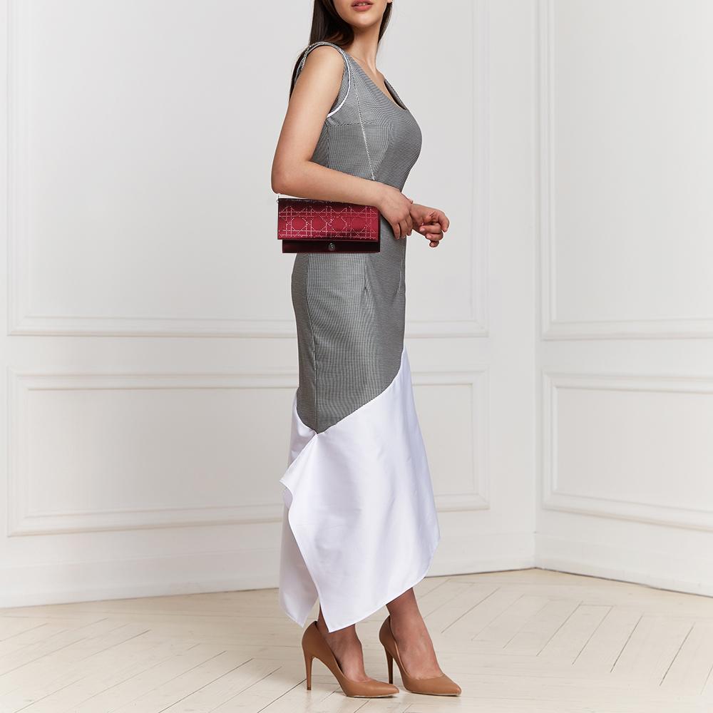 Light up your outfit with this glamorous clutch from the House of Dior. It features an exterior made from burgundy Cannage satin with matching crystal embellishments. It has silver-toned hardware and a satin-lined interior. This clutch is a perfect