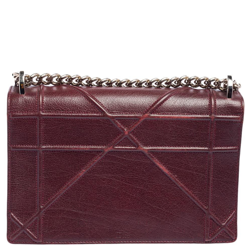 This Diorama bag is simply breathtaking! From its structured shape to its artistic craftsmanship, the bag sweeps us off our feet. It has been crafted from burgundy leather and covered in the brand's signature Cannage pattern. A silver-tone magnetic