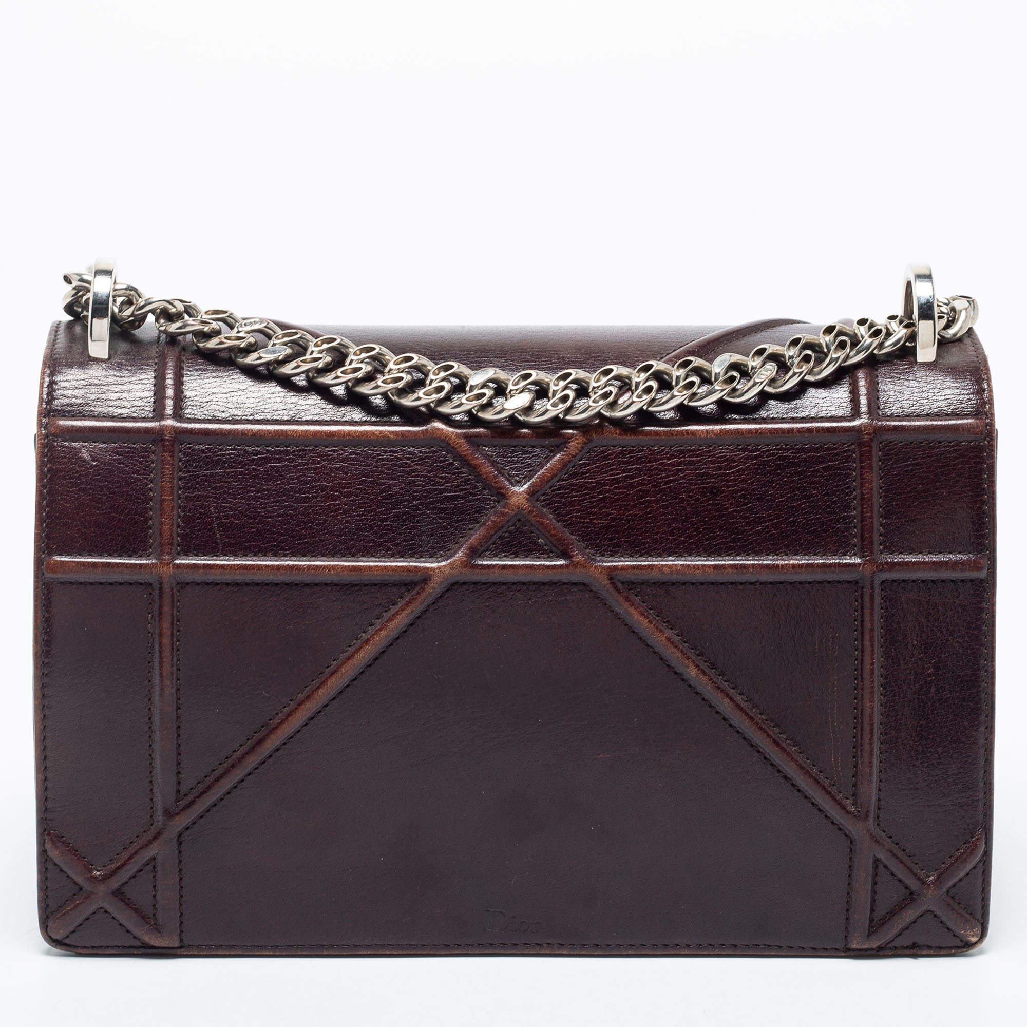 This Diorama bag has been crafted from burgundy leather into a compact design. Magnetic closure on the flap secures a lined interior, and a shoulder chain is provided for you to carry it. You will surely love parading this beauty.


