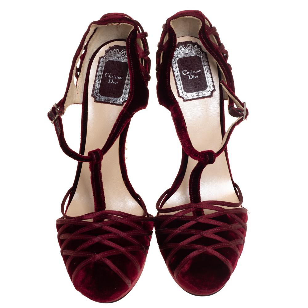 These breathtakingly beautiful pumps by Dior are the most glamorous pair you can possibly own. Crafted from burgundy velvet and satin, these pumps flaunt a round toe and a T-strap silhouette. They feature cross stitch details on the uppers and the