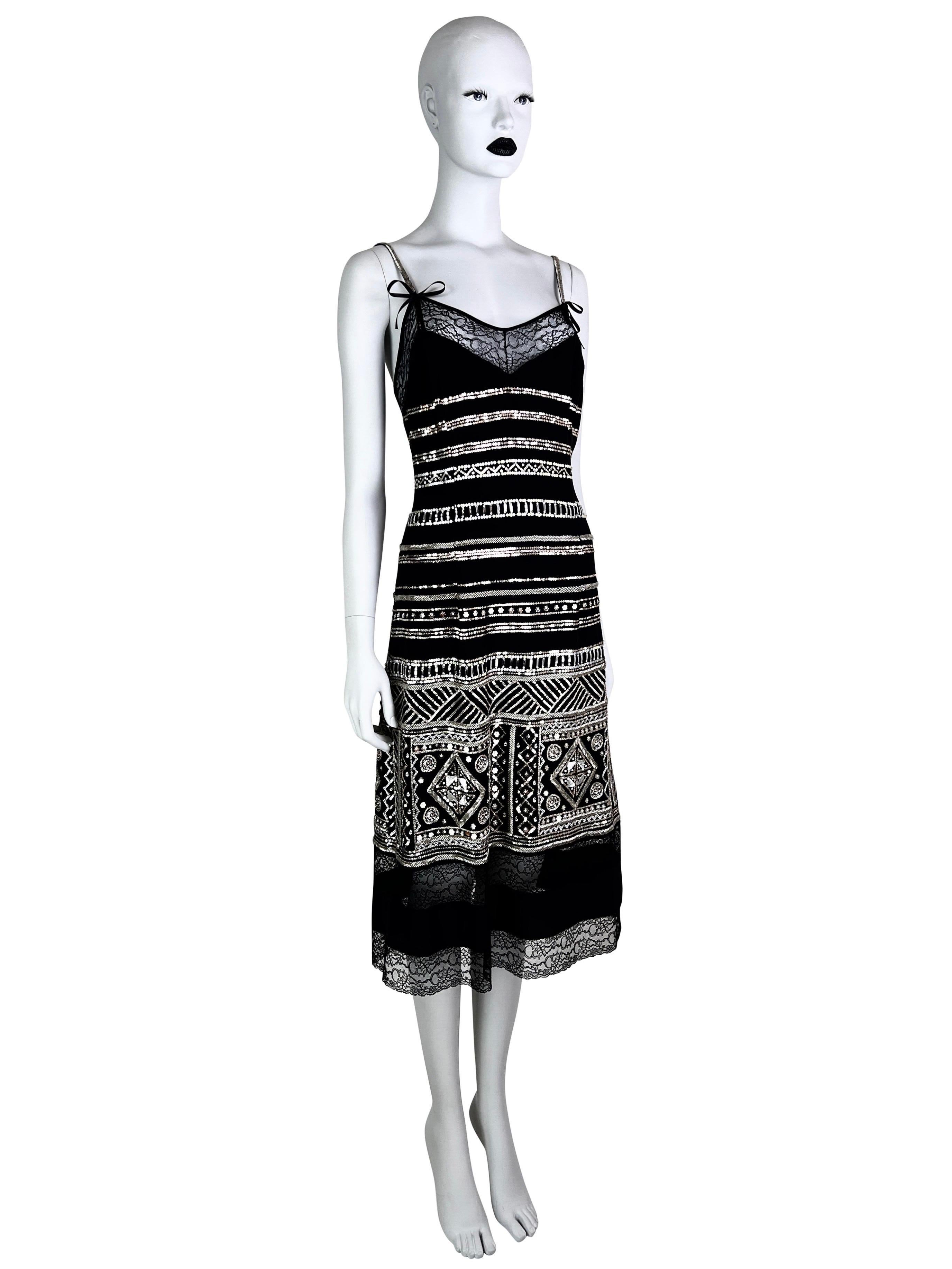 As seen on Rachel Zoe in 2005, this gorgeous silk cami dress is fully embellished with glass beads and sequins. The lace trim has C letters incorporated in a pattern. Closure on a signature for Galliano row of textile buttons. 

Size FR 38,