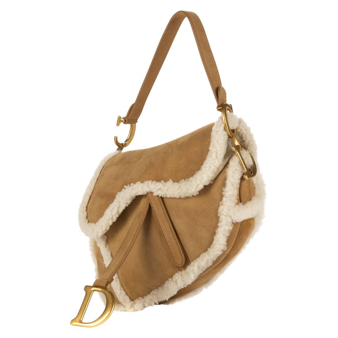 A rare find, this Dior Limited Edition 2020 saddle bag in camel shearling flaunts gold-tone hardware and a magnetic closure. The interior, lined in soft fur, is unpartitioned, making it a statement piece.

SPECIFICS
Length: 9.5