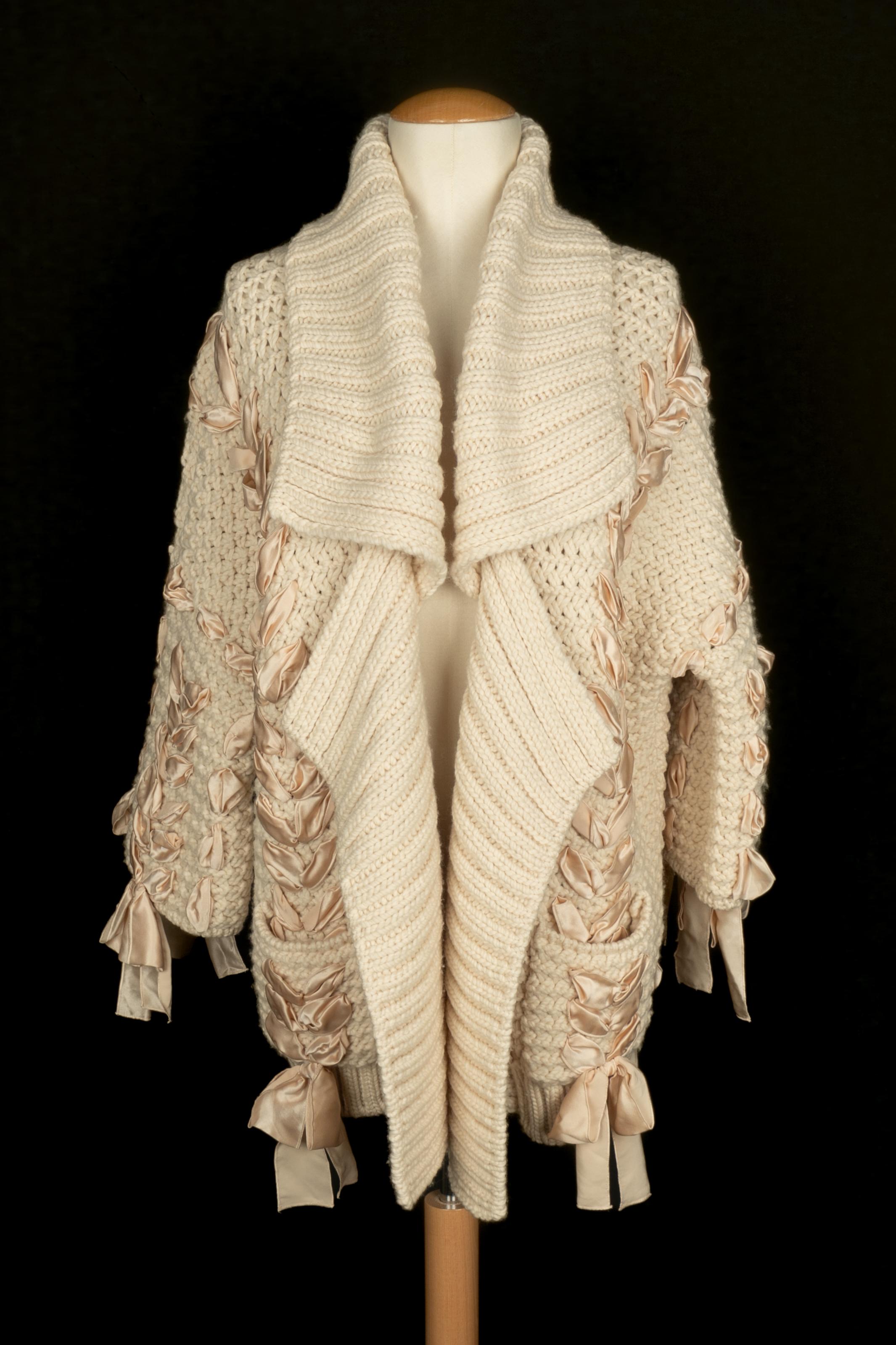 DIOR - (Fabriqué en Italie) Cardigan en laine avec ruban de satin. Taille M. Collectional automne-hiver 2010 sous la direction artistique de John Galliano.

Condit :
Très bon état.

Dimensions :
Largeur des épaules : environ 48 cm - Longueur des