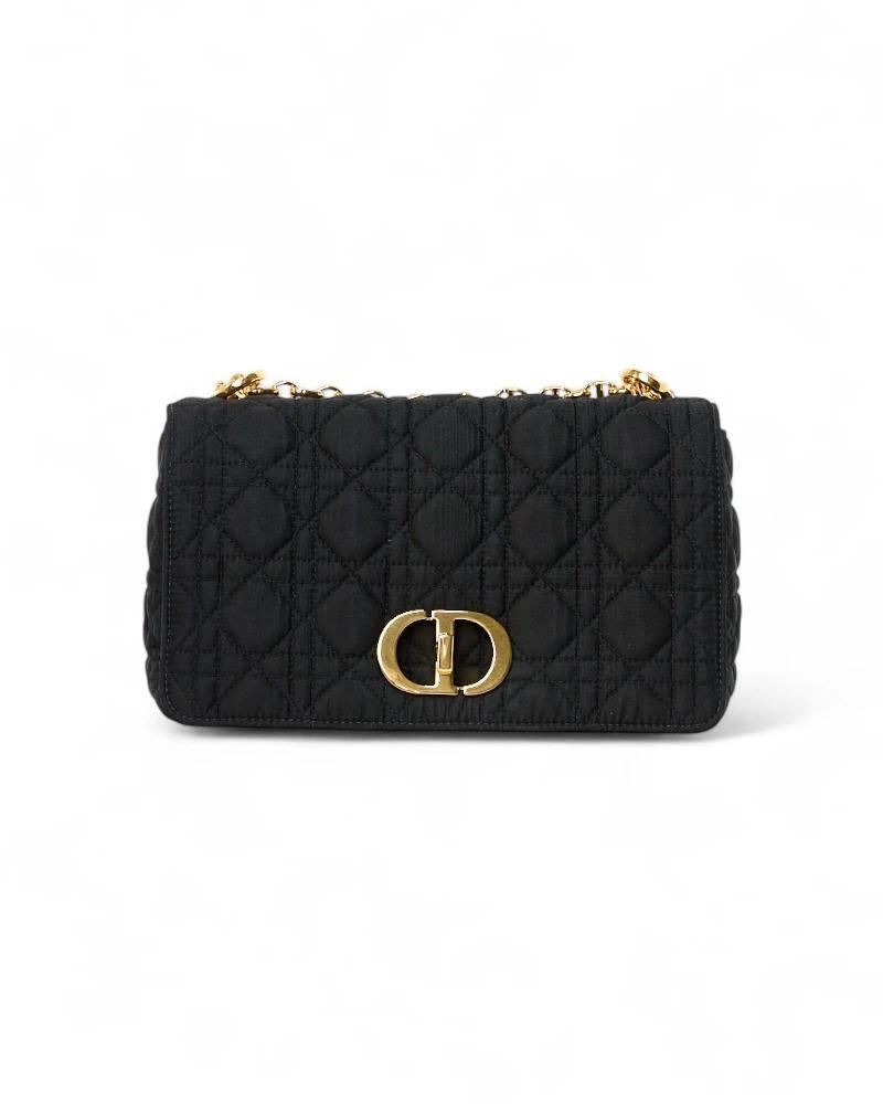Sac de créateur Dior, modèle Caro en taille moyenne, en tissu noir souple avec ferrures dorées. Doté d'un rabat orné du logo classique de la marque et d'une fermeture à verrou tournant, il est doublé à l'intérieur d'un tissu ton sur ton et comporte