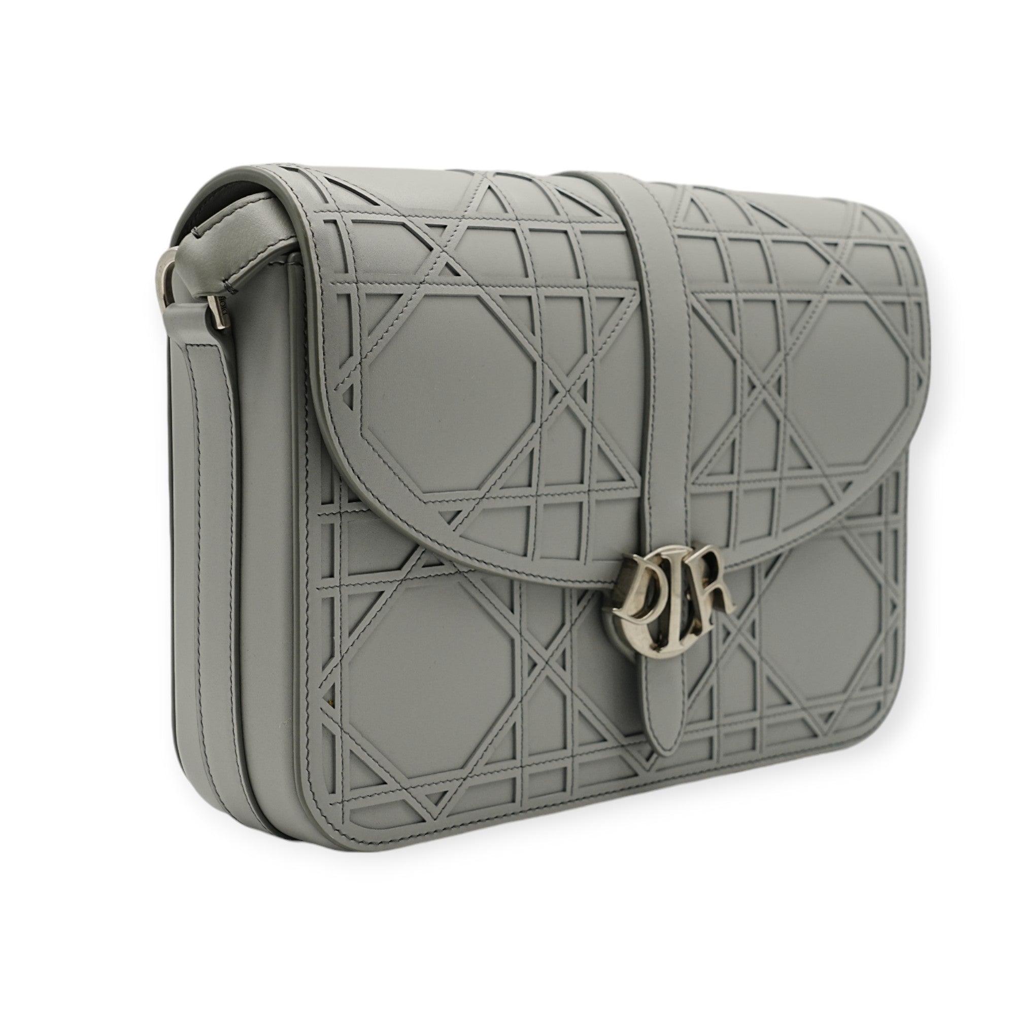The Dior Charm Grey Shoulder Bag exudes a futuristic vibe with its sleek design and modern accents. The muted grey tone enhances its contemporary aesthetic, making it a standout accessory that effortlessly combines elegance with an avant-garde