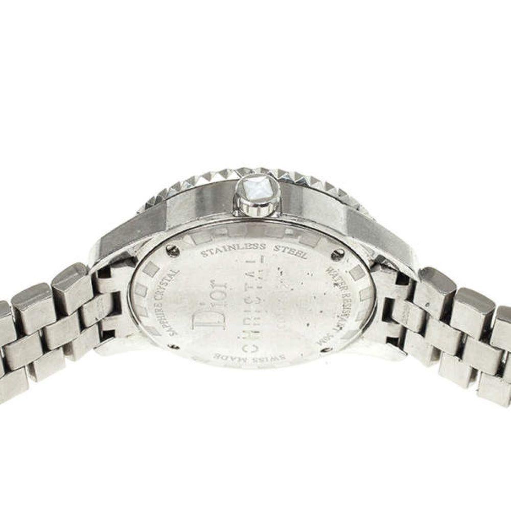 Cette montre christal de Dior est tout simplement magnifique. Le cadran blanc abrite des aiguilles lumineuses, des chiffres arabes et un guichet de date. La lunette est incrustée de 0,2 ct de diamants. Le bracelet en acier inoxydable est rehaussé de