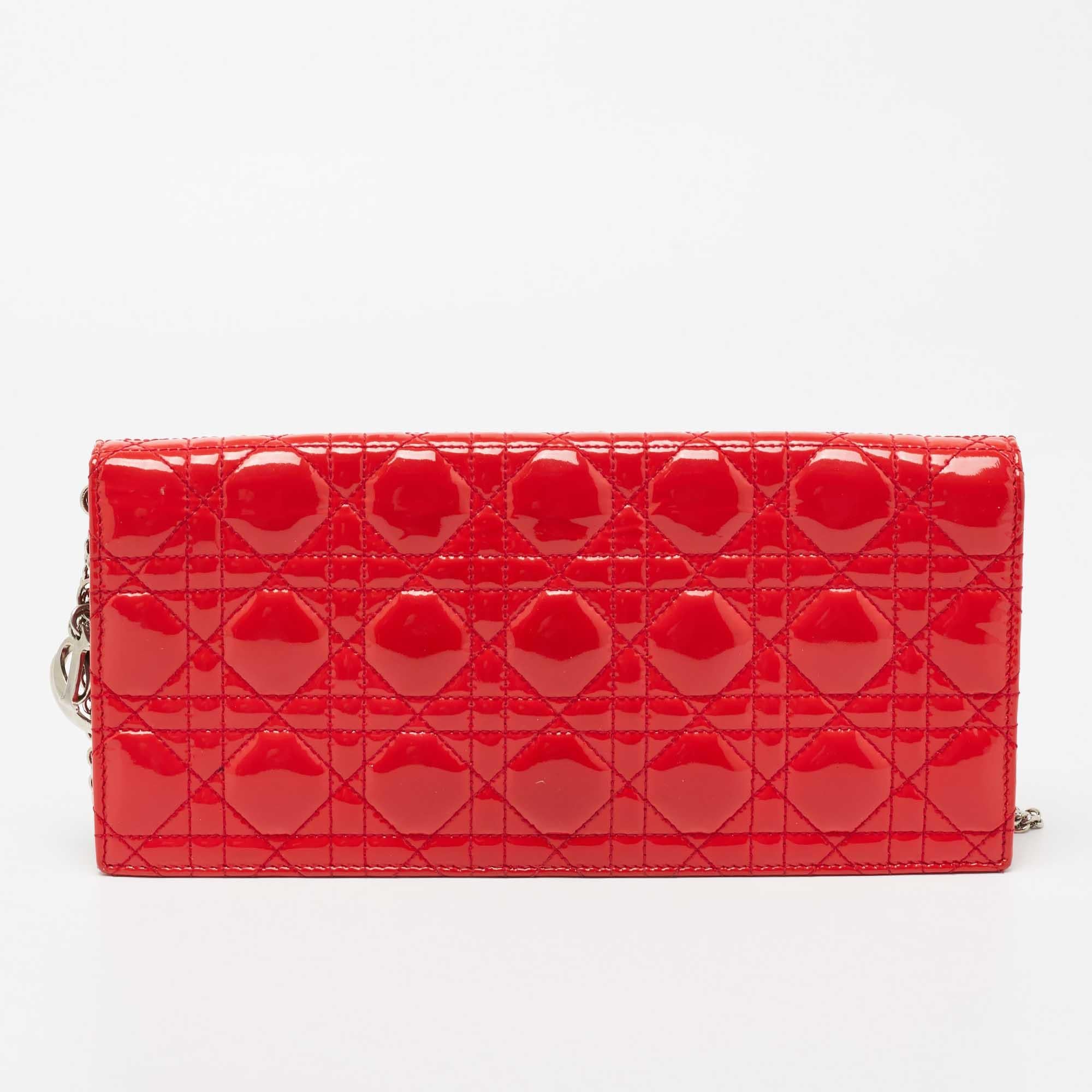 This exquisite Lady Dior clutch from Dior is a chic accessory that represents the brand's rich aesthetics and elegant designs. Crafted from quilted Cannage patent leather, the coral red clutch has a flap style with logo letter charms on the side.