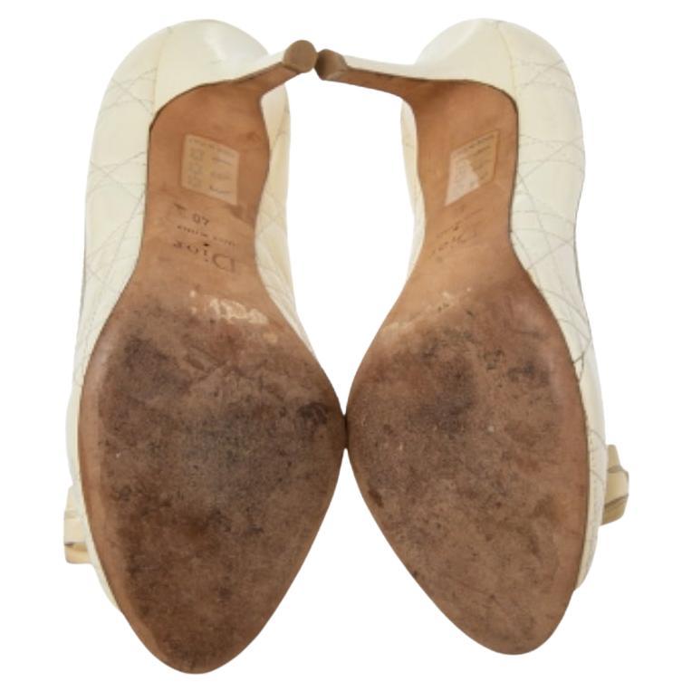 Infuse your style with a blend of grace and elegance by wearing these pumps from the House of Dior. They are created using cream Cannage patent leather on the exterior and exhibit a bow accent on the front, peep-toes, and 9.5 cm pointy heels. Wear