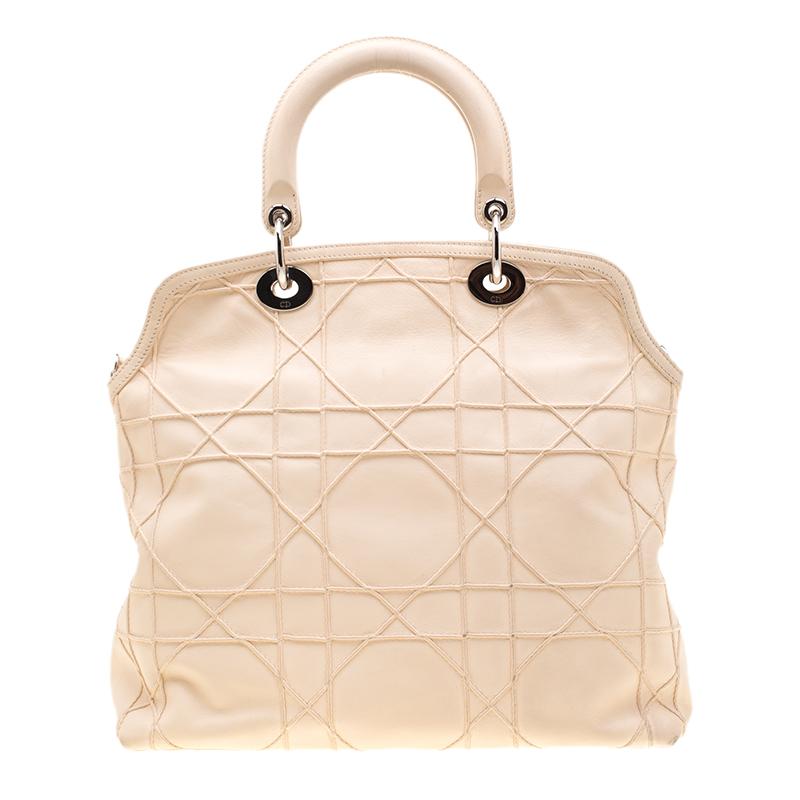 This chic and feminine Granville tote is from Dior. The bag is crafted from Cannage quilted leather. Cream in colour, it is easy to carry around. It features dual handles with the signature 'DIOR' accents and protective metal feet. The interior is