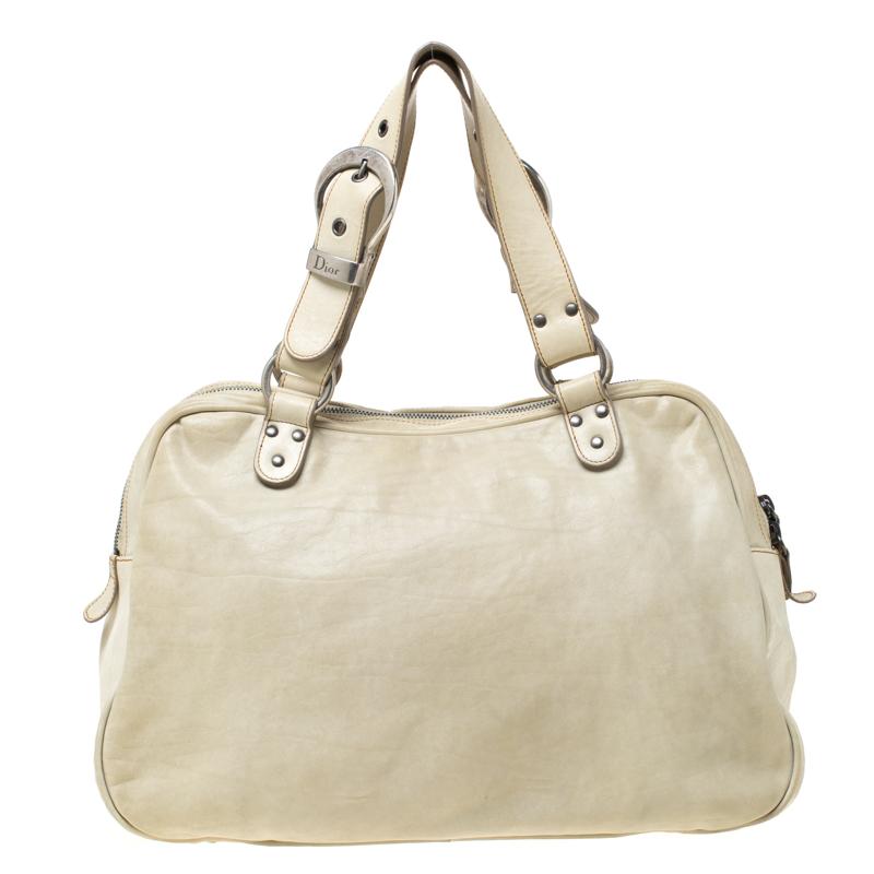 From the house of Dior, this Gaucho Double Saddle bag is an excellent blend of elegance and style. It comes in a cream hue that is perfect for making a statement. The bag features with a chunky buckle, a key and a fabric-lined interior. Make an