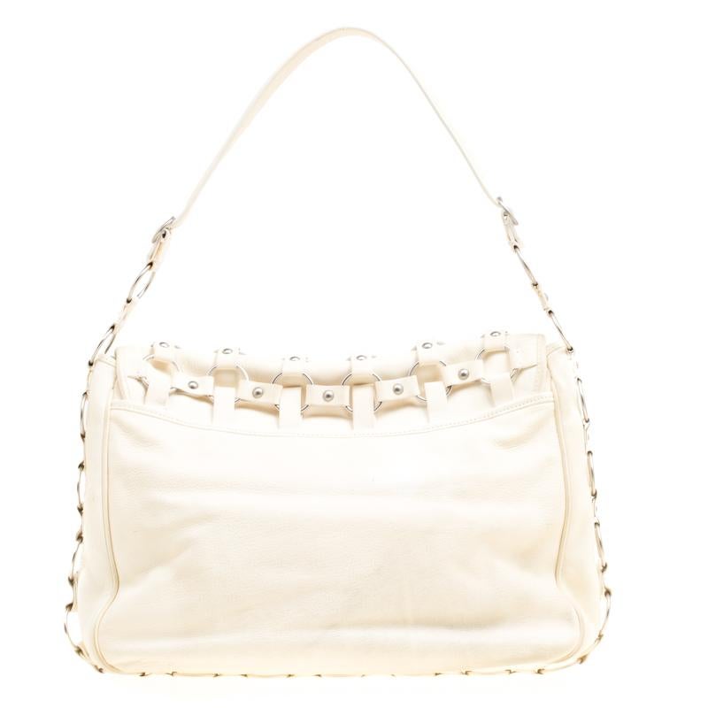 Designed in a subtly slouchy silhouette, this Croisette hobo from Dior is designed in a cream leather body and detailed with an interesting web-like pattern accented from leather, metal rings and studs. It comes with a leather shoulder strap and