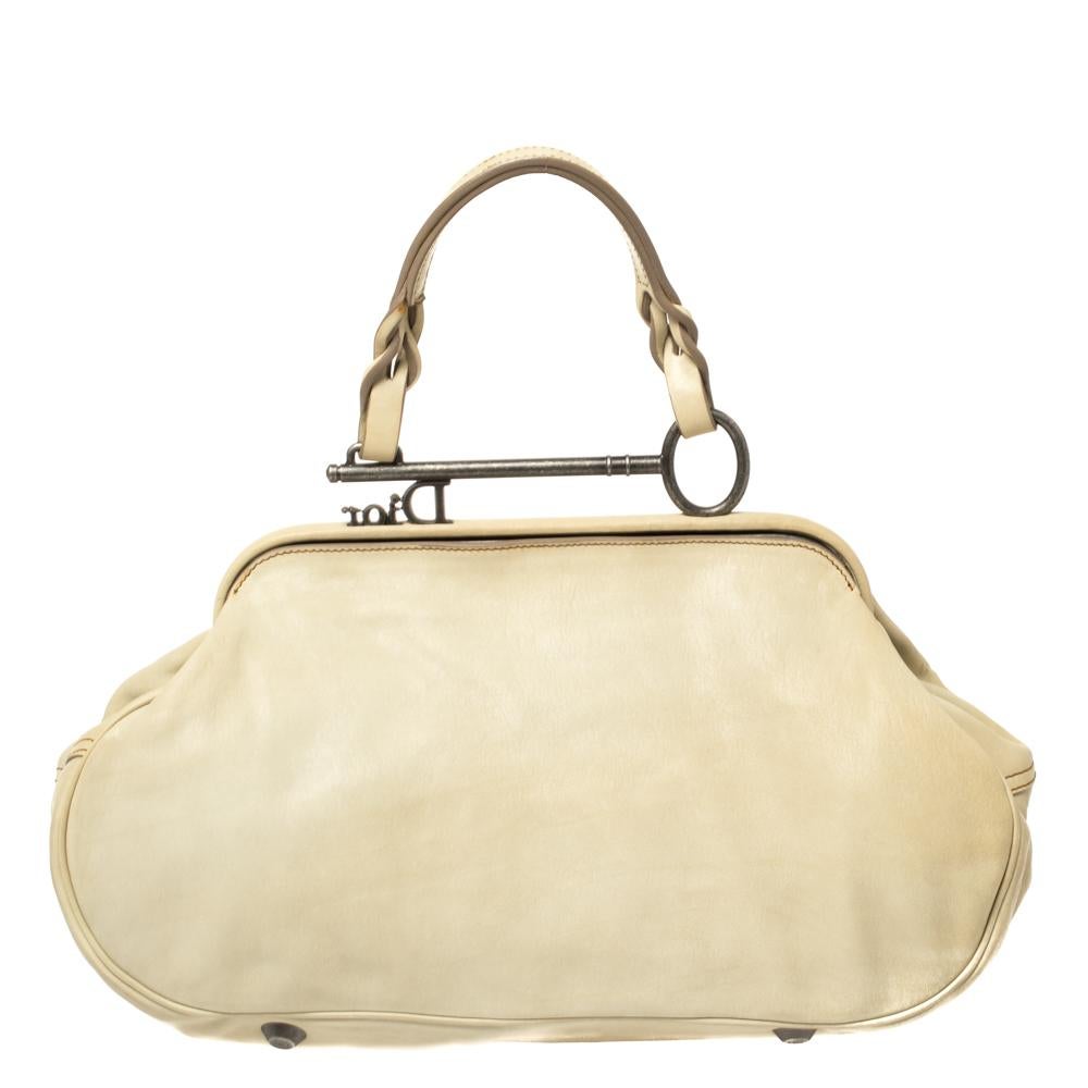 Inspired by the shape of a saddle, the popular rustic style Dior Gaucho bag is a unique bag to own. The Gaucho bag’s exterior is made from cream leather that folds over to resemble an old western saddle. It is accented with Dior engraved key charms