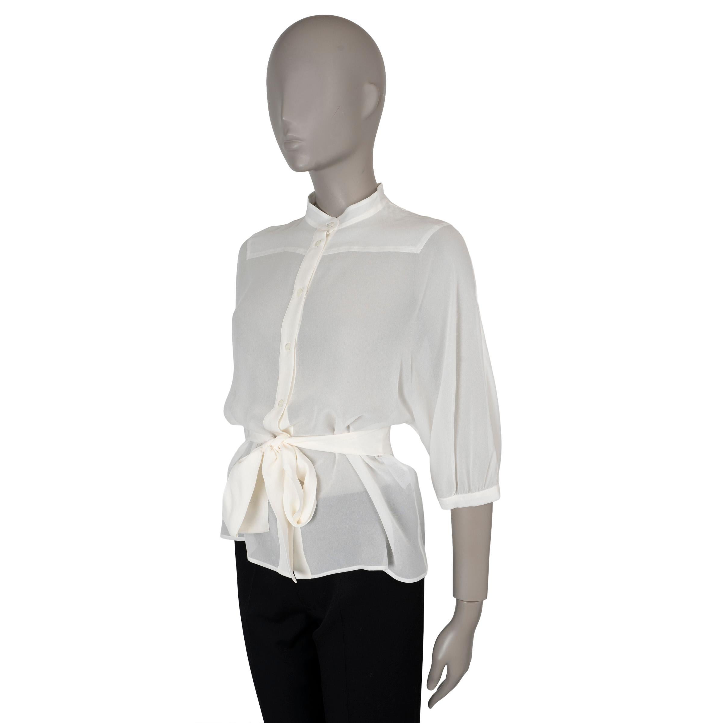 This 100% authentic Christian Dior blouse in cream chiffon silk exudes timeless elegance. It features a flared silhouette that cinches at the waist with a matching self-tie belt, creating a flattering shape. Designed with 3/4 batwing sleeves,