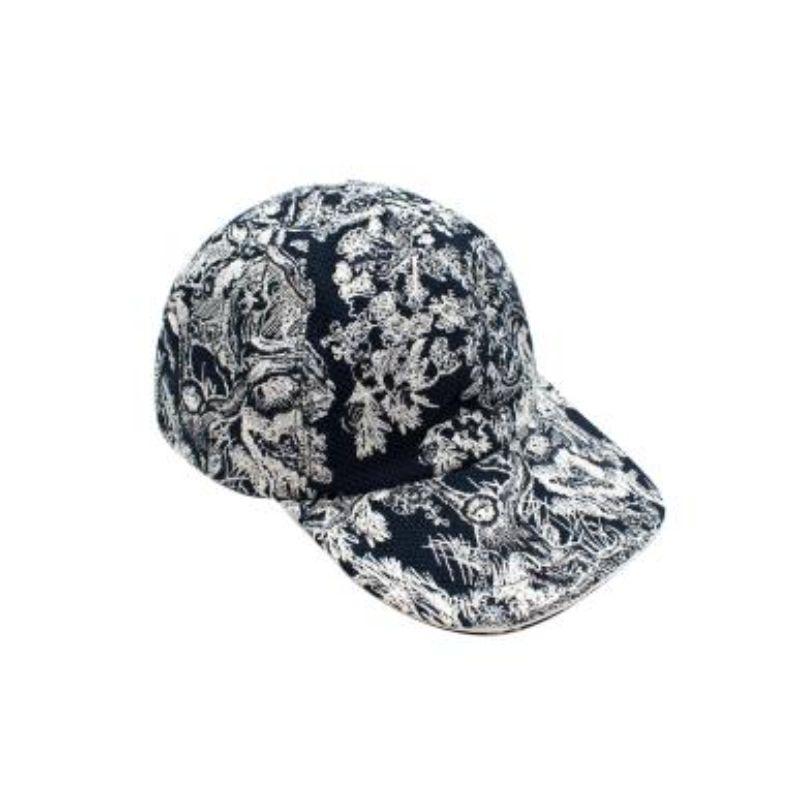 Dior D-Player Toile De Jouy Sauvage Cap 

-Doublée 
-Corps imprimé blanc et marine 
-Dos réglable par velcro 
- Forme ronde 

Matériau :

90% coton 
10% Polyéthylène 

Fabriqué en Italie 

VEUILLEZ NOTER QUE CES ARTICLES SONT DES ARTICLES D'OCCASION