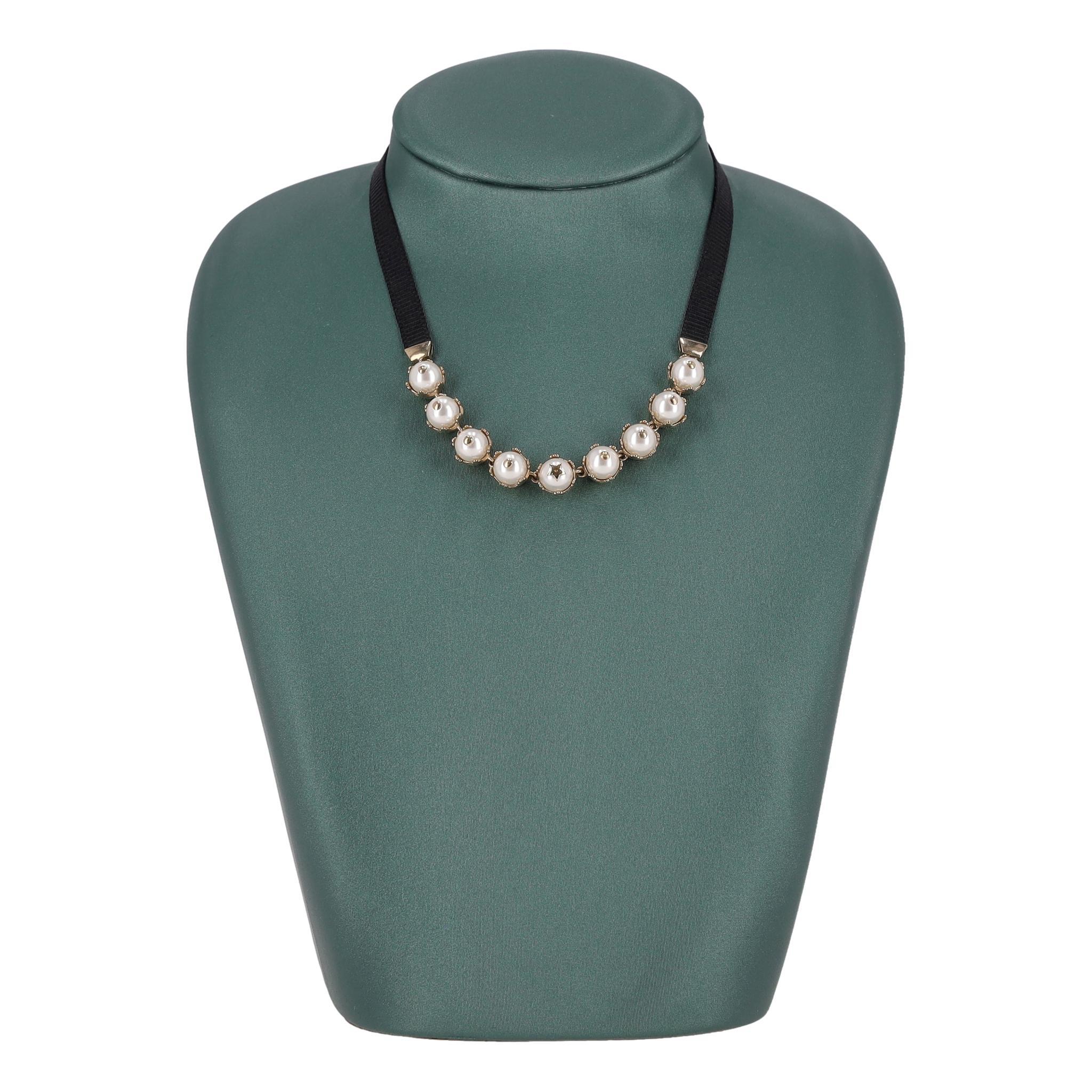 Girocollo di perle Dior D-Renaissance

Della collezione D-Renaissance di Dior, realizzato in metallo dorato e nastro in gros grain nero.

Presenta perle in resina ornate da punti dorati, con una perla centrale evidenziata da un dettaglio a