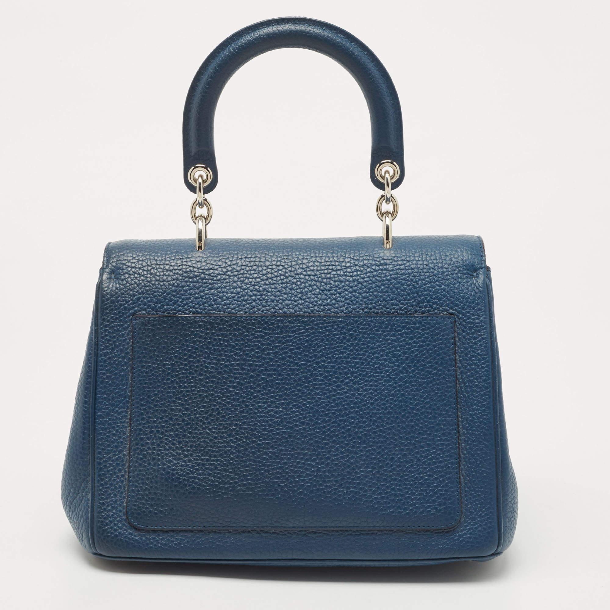 Pretty in dark blue, this Dior bag is crafted from leather and designed with a front flap and dual handling options. The leather-lined interior houses an open compartment that can easily accommodate your daily essentials, and the bag is complete