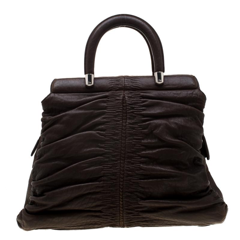 There won't ever be a day when you won't want to carry this Karenina Hermitage bag by Christian Dior. This intricately pleated bag is crafted from dark brown leather and designed with a CD detail and framed top handles. The fabric-lined interior