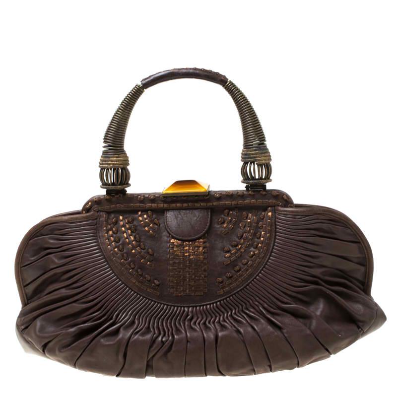 Expertly crafted from dark brown leather, this Plisse bag exhibits an exquisite design. The bag features a single handle and the interior is lined with nylon. With a pleated exterior, the Dior bag is an indispensable accessory and is surely a