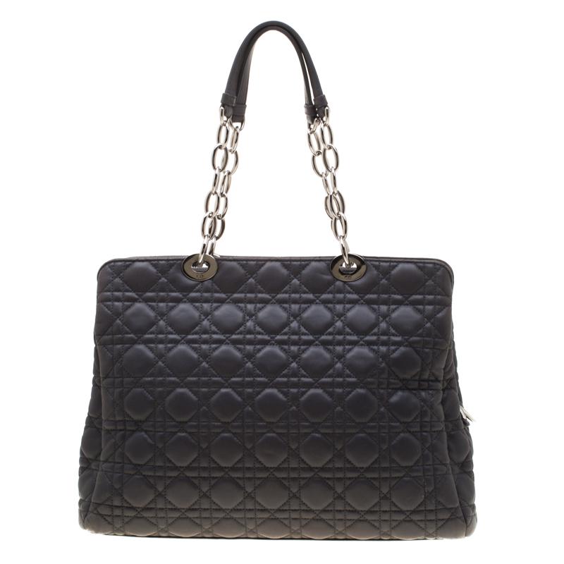 The Lady Dior tote is a Dior creation that was designed in 1994 and has gained lovers worldwide. Crafted from dark grey leather, this shopper tote carries the signature cannage pattern all over the exterior. It is equipped with dual chain link