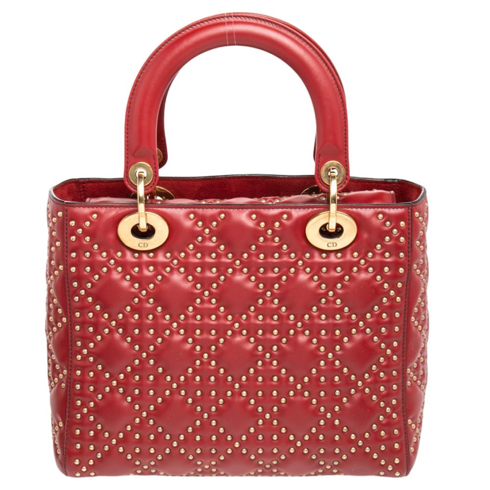 The Lady Dior tote is a Dior creation that has gained recognition worldwide and is today a coveted bag that every fashionista craves to possess. This dark red tote has been crafted from studded leather and it carries the signature Cannage quilt. It