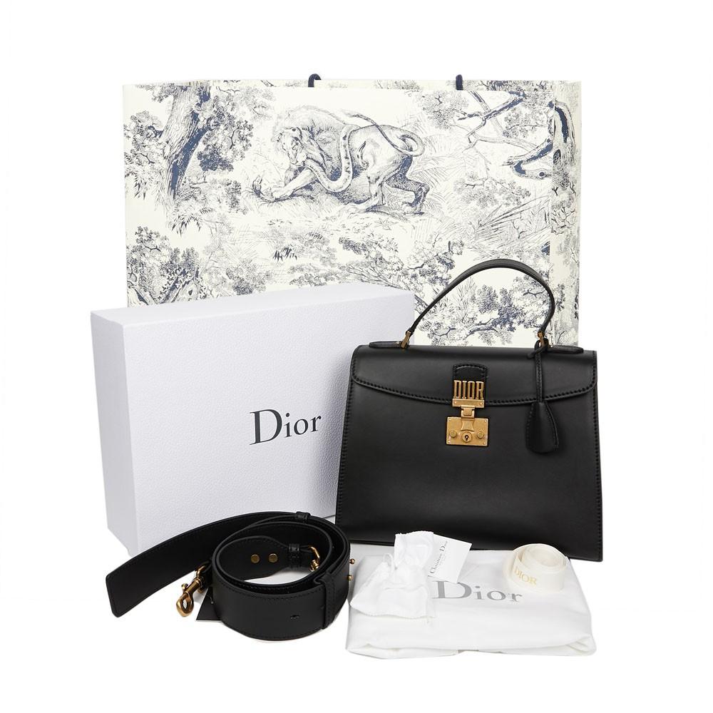 This Dioraddict large bag is made of black calfskin leather with aged gold metal trimmings. It is a flap bag with an S lock, and above the clasp is a Dior plaque, the emblem of the collection. 
It is lined in black suede with two large pockets. It