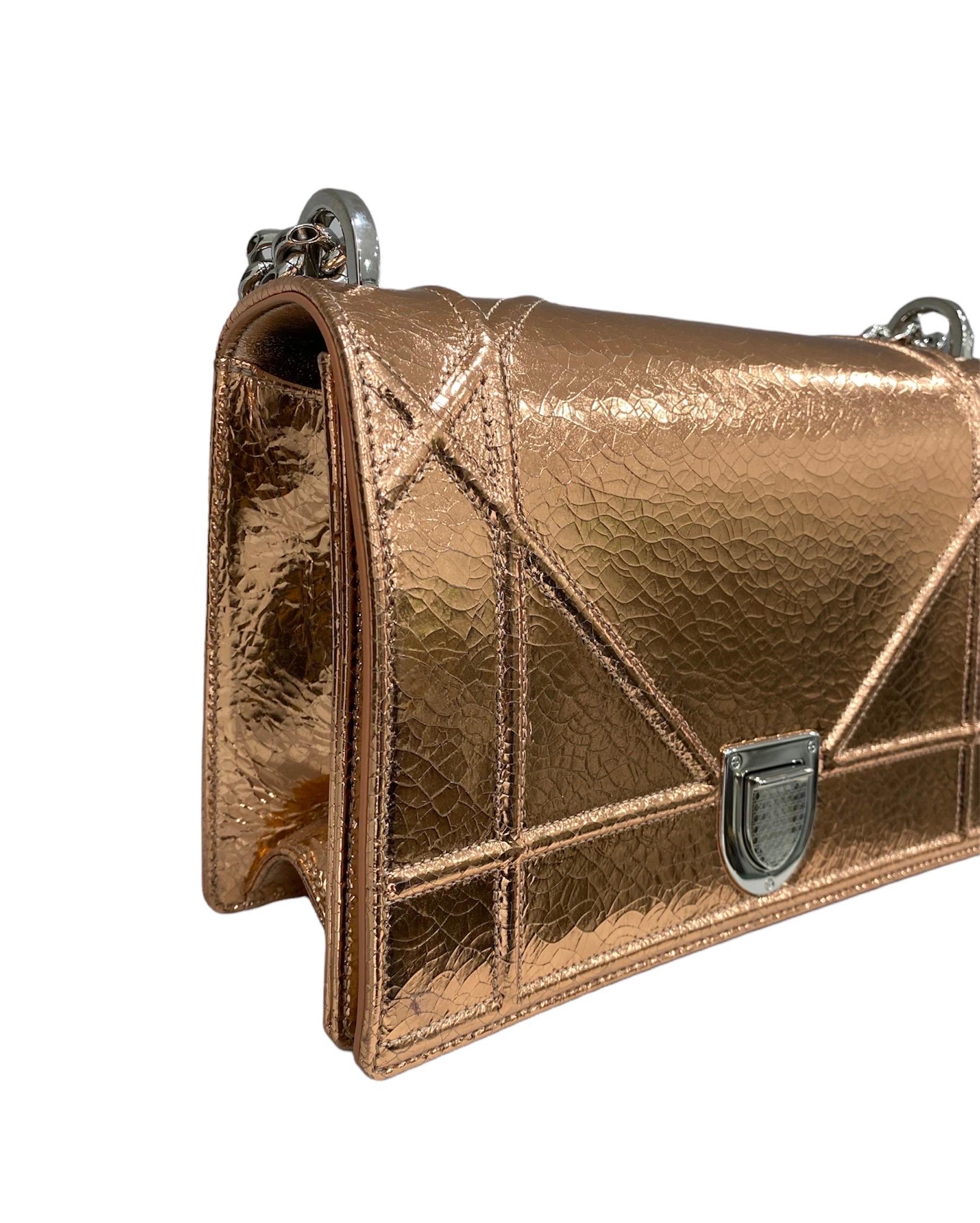 Dior Diorama model shoulder bag in copper-colored shiny leather with silver hardware.

It has a front flap with interlocking closure. The interiors are lined with a black fabric and is equipped with internal pockets including one with zip closure,