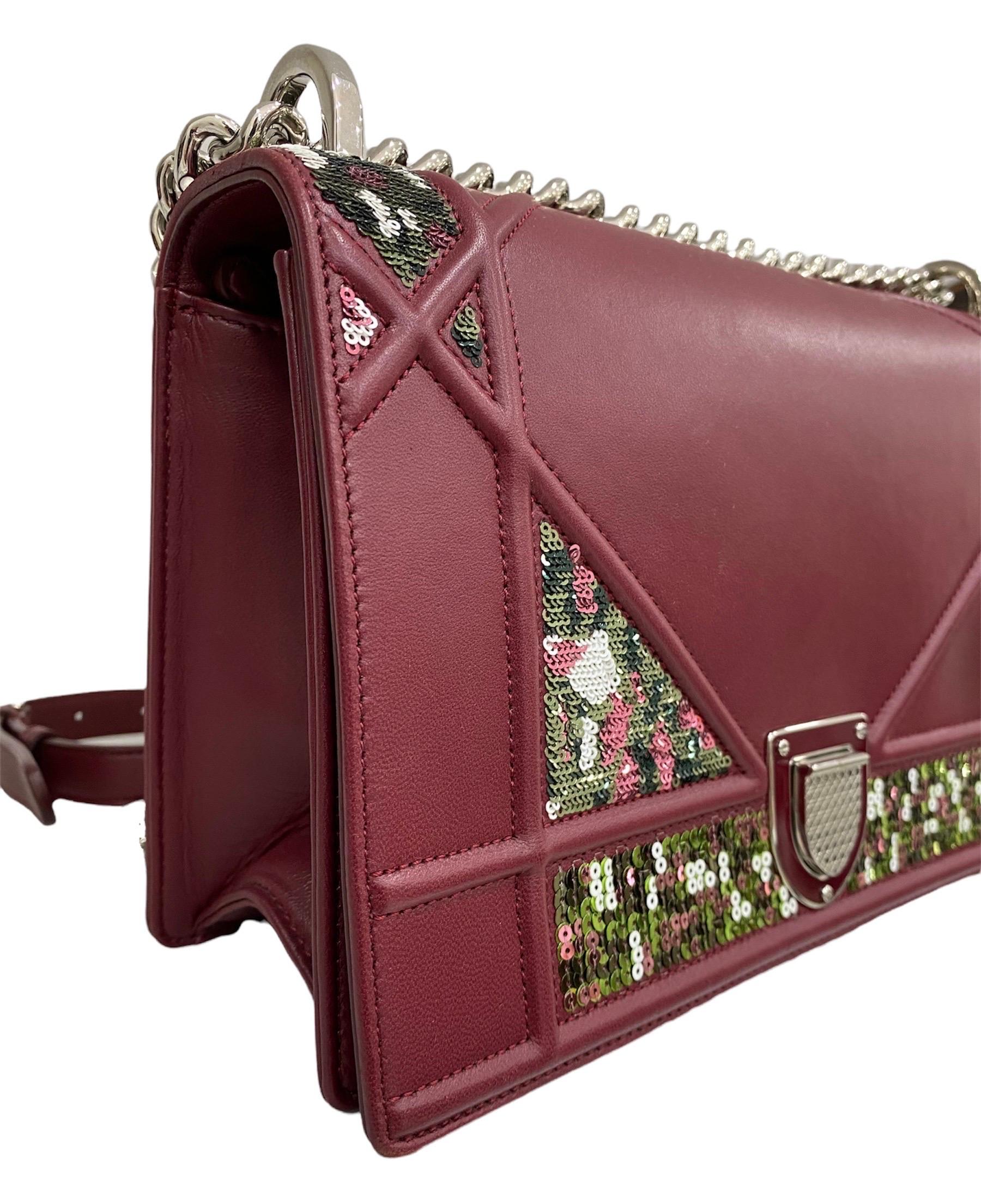 Dior Diorama model shoulder bag in burgundy leather and multicolor sequins with silver hardware.

It has a front flap with interlocking closure. The interiors are lined in green leather and is equipped with internal pockets including one with zip