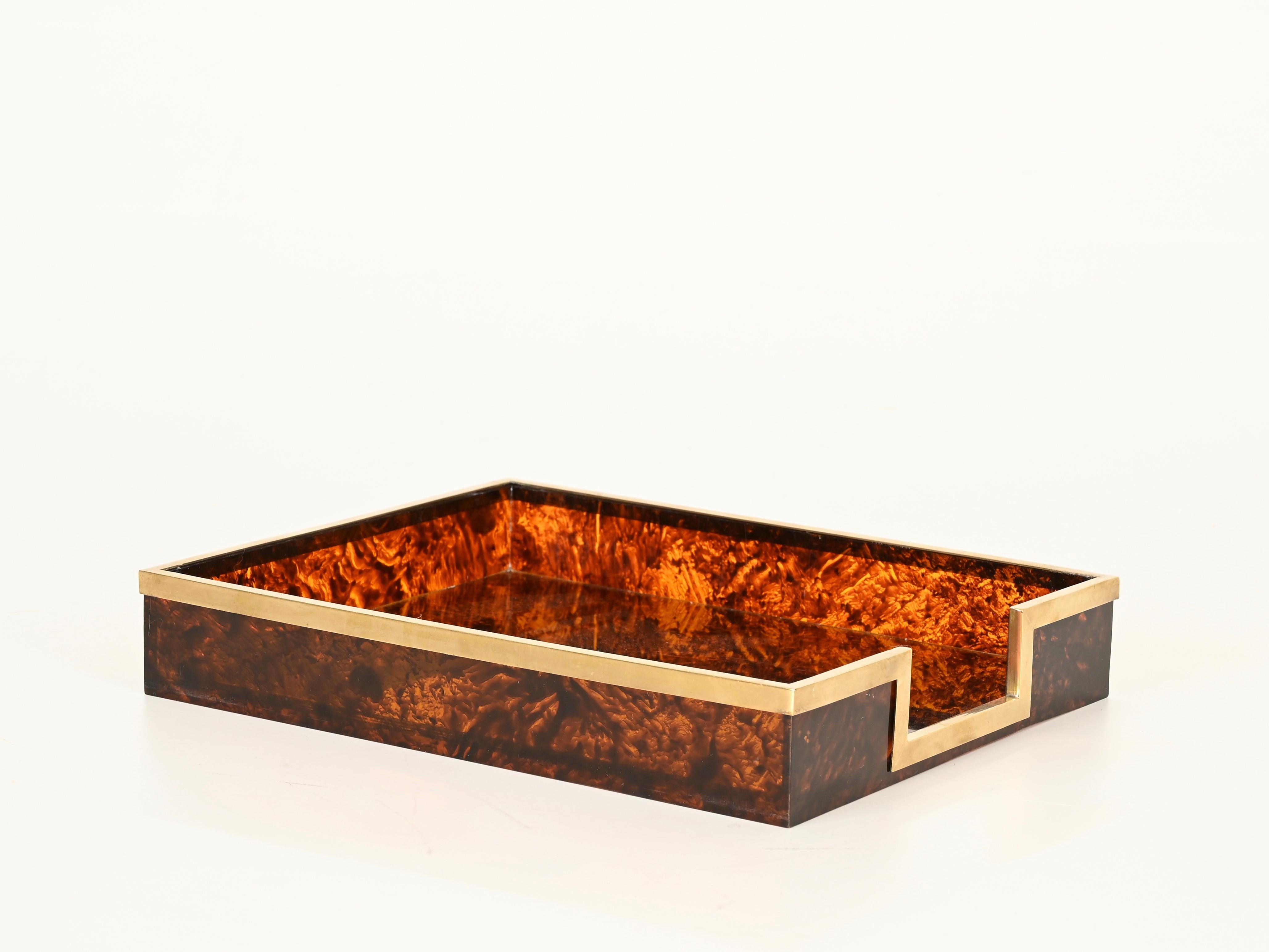 Merveilleux porte-documents ou porte-revues du milieu du siècle, entièrement réalisé en Lucite à effet écaille vibrante, avec un cadre en laiton massif poli. Cette pièce élégante et vraiment unique a été produite en Italie dans les années 1970, et