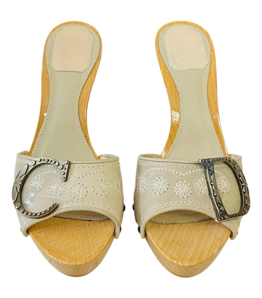 Dior Embroidered Leather 'CD' Clog Sandals

Ivory heels with wide embroidered strap detailed with 'C' and 'D' ruthenium letters with decorative engravements.

Featuring high wooden heels and platform, leather lining.

Size – 36.5

Condition –Good