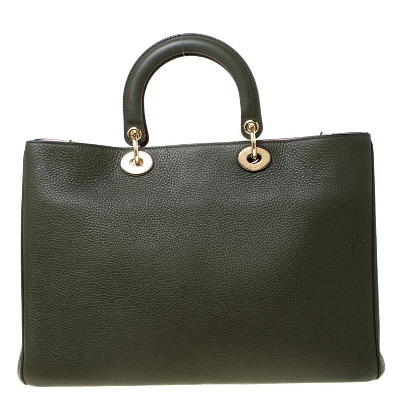 The Diorissimo bag from Dior is a timeless piece. The leather bag comes in a luxurious emerald green hue with gold-tone hardware and Dior letter charms. It features double top handles, a detachable shoulder strap and protective feet at the bottom. A