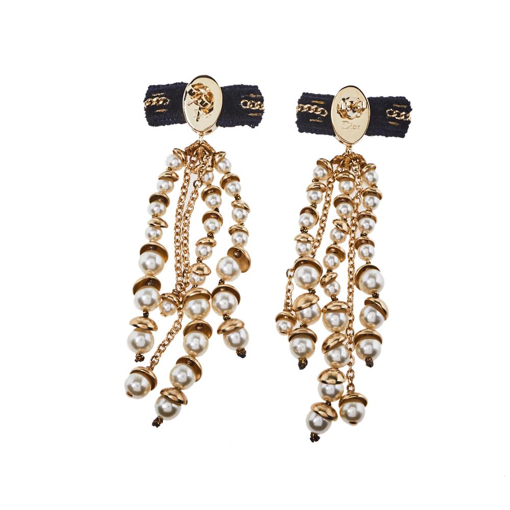 Exhibiting the rich craftsmanship and creativity of the brand Dior, these earrings are so elegant, and pretty they are meant to be flaunted. They feature fabric accents and gold-tone metal from which dangles long faux pearls and chains. The screw