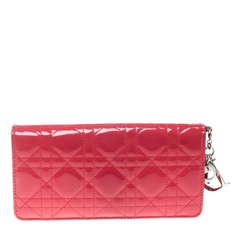 Fuchsia looks beautiful on this Christian Dior Lady Dior wallet that has been crafted with cannage quilted glossy patent leather. The exterior features Dior charms in silver-tone and a zip around closure. The interior is leather lined and features