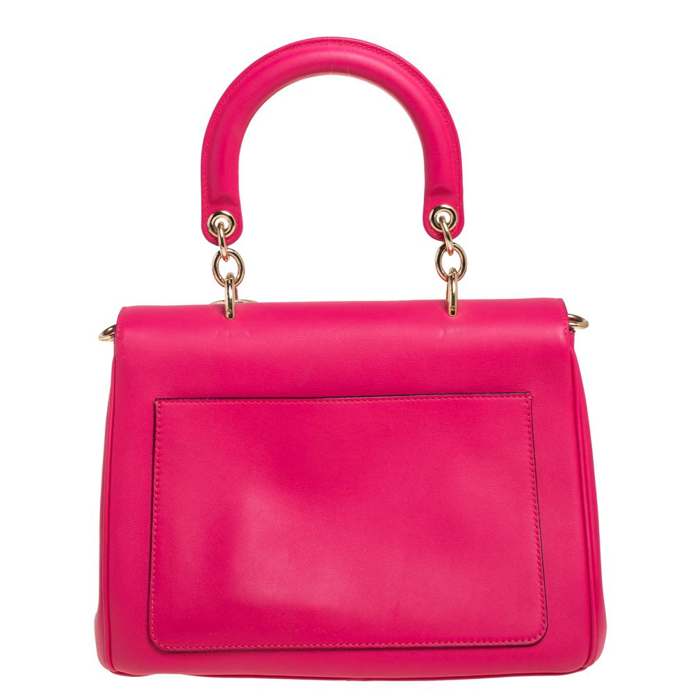 Diese Be Dior Tasche aus dem Hause Dior wird Ihrer Garderobe einen Hauch von Luxus verleihen! Es ist aus Leder gefertigt und hat eine schicke Silhouette. Es glänzt mit einem einzelnen gerollten Griff oben mit angebrachten „DIOR“-Buchstaben-Anhängern
