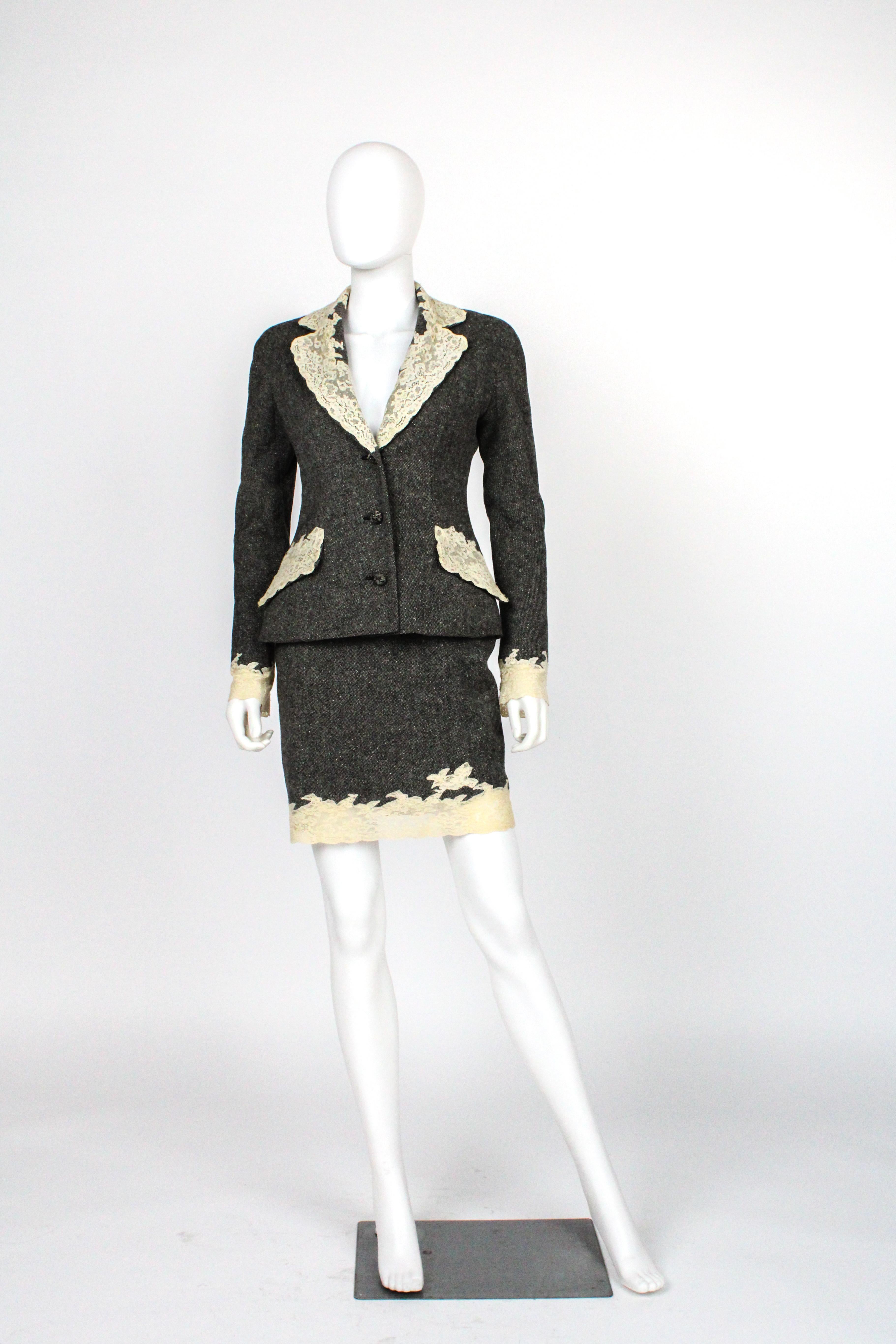 - Guaranteed 100% Authentic.

- Excellent preowned condition.

- Description: grey donegal tweed skirt suit edged in white calais lace. 

- Size: Jacket marked 6 US, Fits 2-4. Chest: 17”, Waist: 14”, L: 26”, arm inseam: 19” and armpit: 7.5”. Skirt