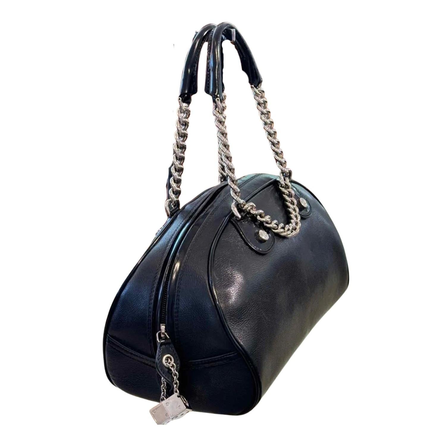 This Boston bag is made of calfskin leather in black. It features silver chain link top handles with leather grips and hanging dice embellished with crystal Dior logos. The top zipper opens to a monogram fabric interior with a zipper pocket.

Color: