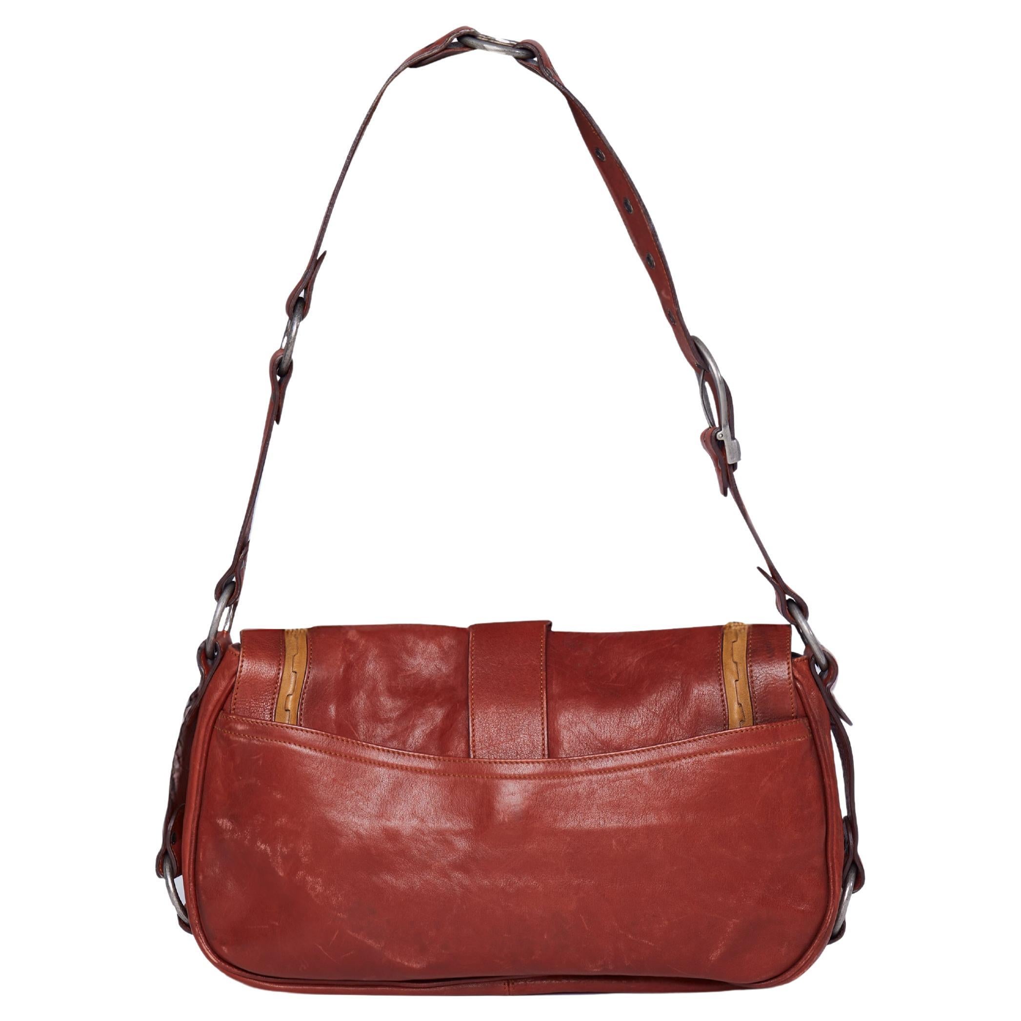 Christian Dior Gaucho Saddle Bag - Circa 2005
Pièce emblématique de l'ère John Galliano chez Dior, le sac Gaucho Saddle Bag allie les références équestres de l'Ouest à l'esprit parisien. Confectionné en cuir rouge vieilli, ce modèle asymétrique et