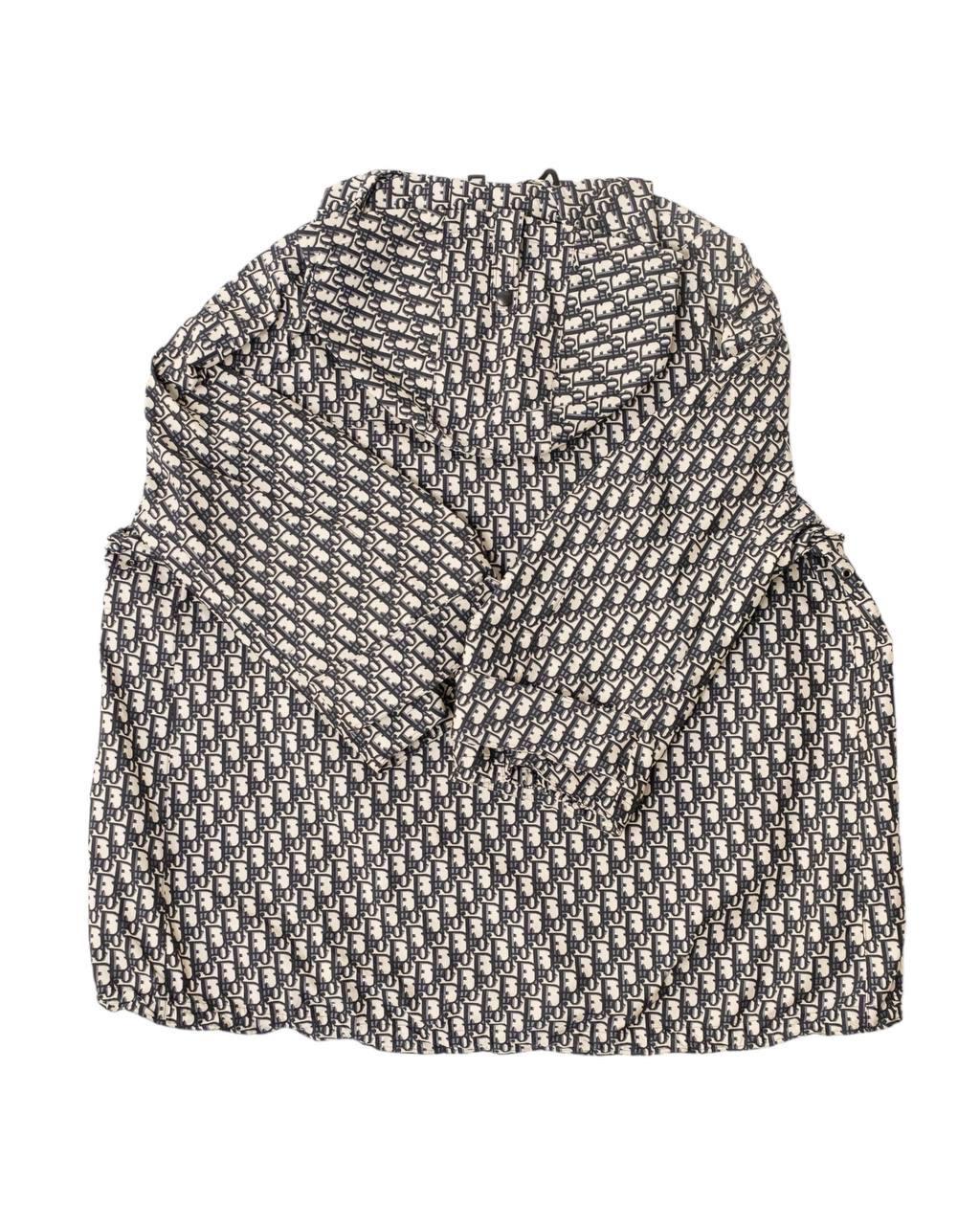 Giacca firmata Dior, modello Anorak con cappuccio, realizzata in 100% poliestere blu e beige con motivo Dior Oblique. Taglia XS, dotata di uno scollo frontale con cerniera e di cappuccio. Munita di una coulisse sulla parte inferiore per stringerla.