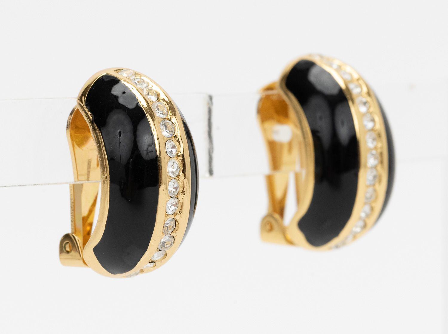 Clip on di Christian Dior anni '80 in nero con una linea orizzontale di strass in oro. In ottime condizioni. Viene fornito con un sacchetto di velluto. 