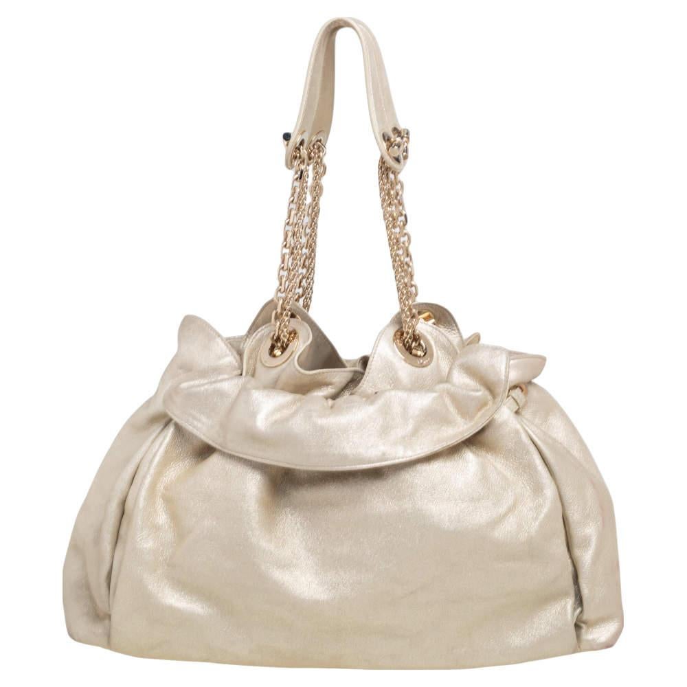 This stylish Le Trente hobo from Dior has been crafted from gold leather. The bag features dual chain straps with leather shoulder rest, a CD cutout charm in gold-tone metal, a drawstring closure, and protective metal feet at the bottom. The insides