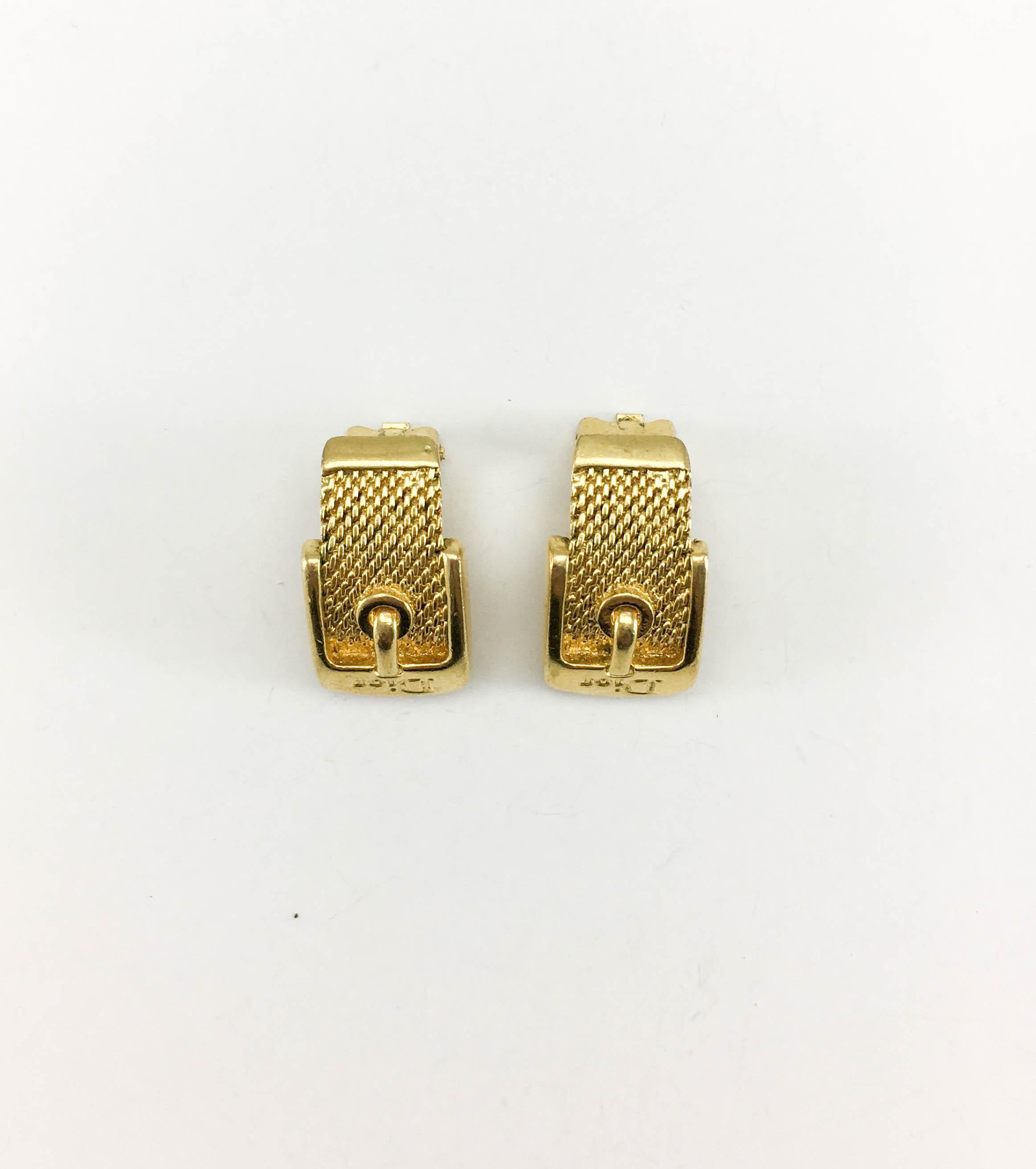 Vintage Dior Gilt Clip-On Buckle Earrings. These stylish earrings by Dior date back from the early 2000’s. Made in gilt metal, they are shaped as a buckle reading ‘Dior’ on the top. Dior signed on the back. The perfect understated piece of fashion