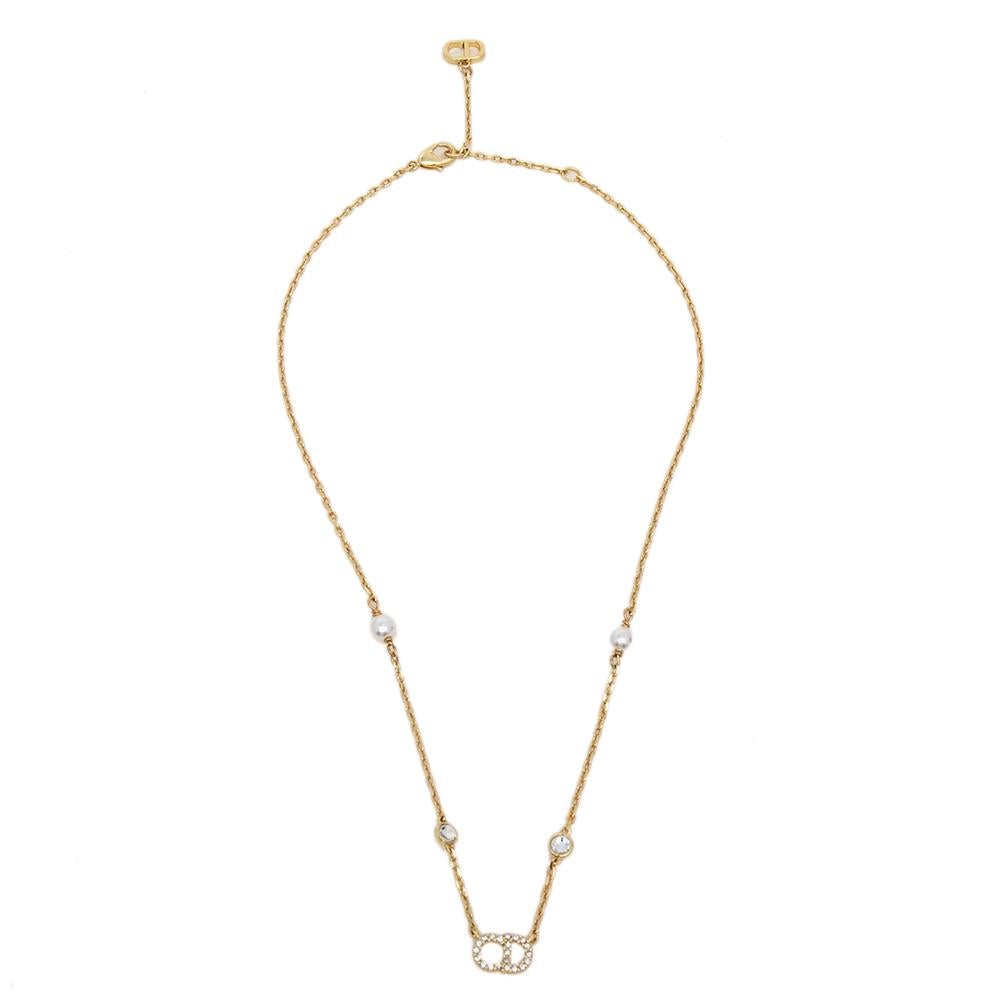 Parfois, les designs les plus simples sont les plus époustouflants. Ce magnifique collier Clair D Lune est signé Dior. Il a été réalisé en métal doré et la chaîne contient de fausses perles et les motifs CD caractéristiques, le pendentif étant