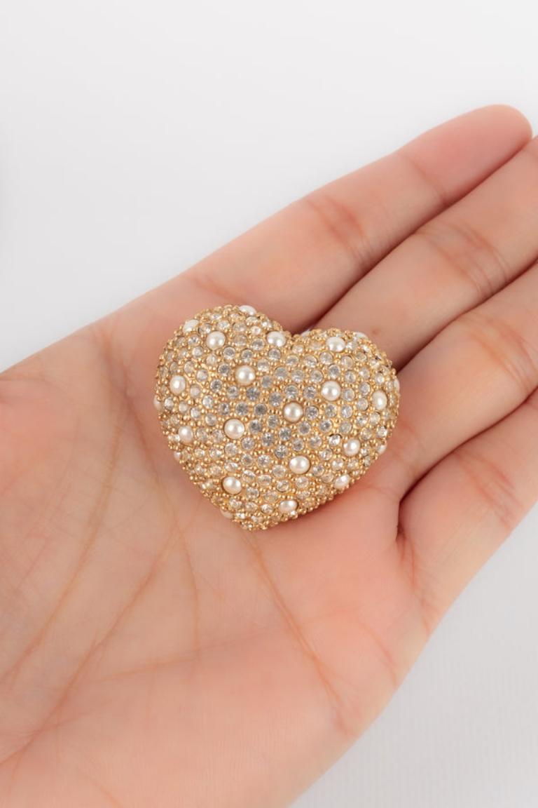 Dior - Golden metal heart brooch with rhinestones and tiny pearly cabochons.

Additional information: 
Condition: Very good condition
Dimensions: 3 cm x 3 cm

Seller Reference: BR131