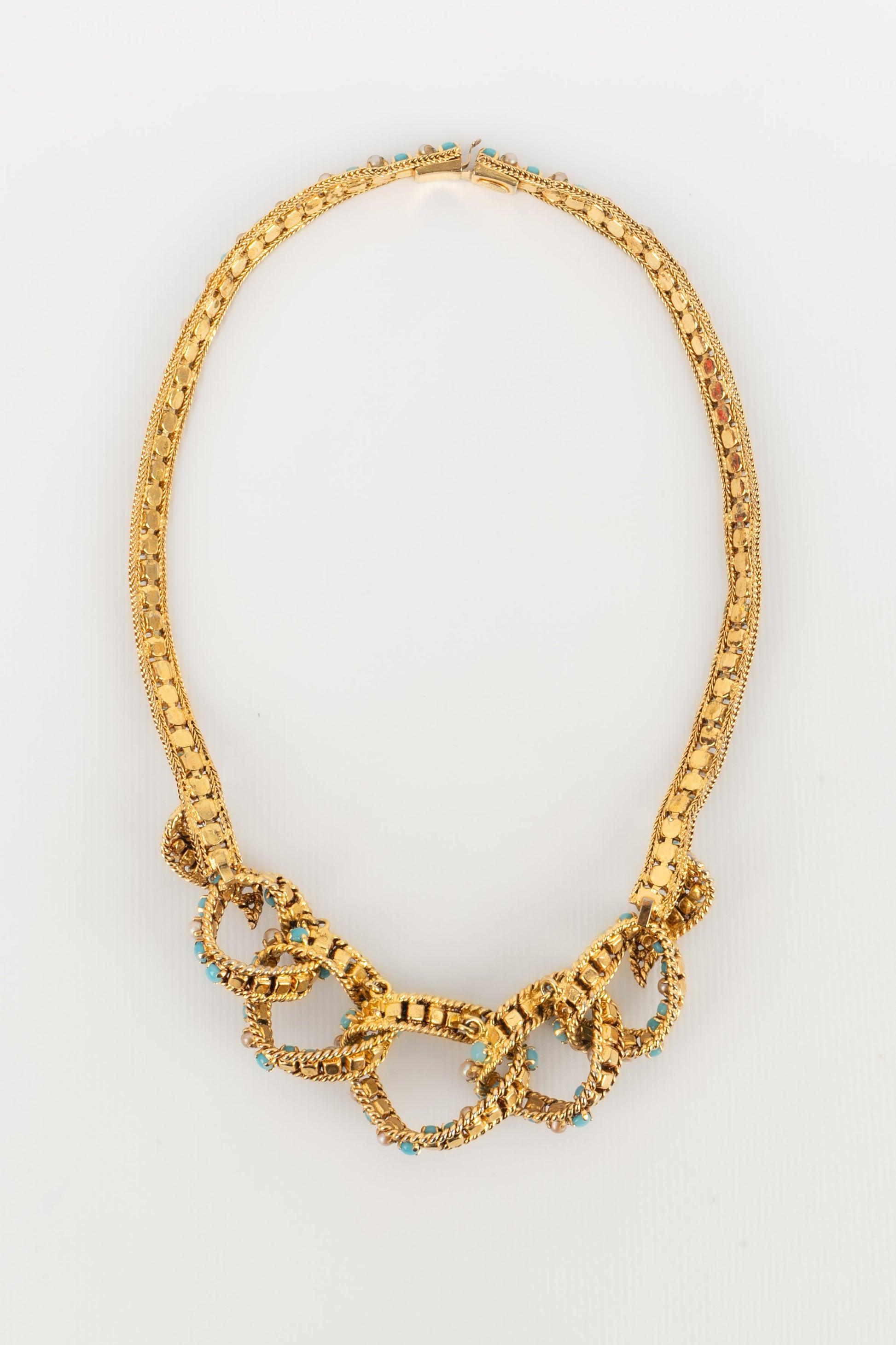 Dior - Golden metal necklace ornamented with costume pearly cabochons and blue glass paste. 1965 Collection.

Additional information:
Condition: Good condition
Dimensions: Length: 40 cm
Period: 20th Century

Seller Reference: BC209