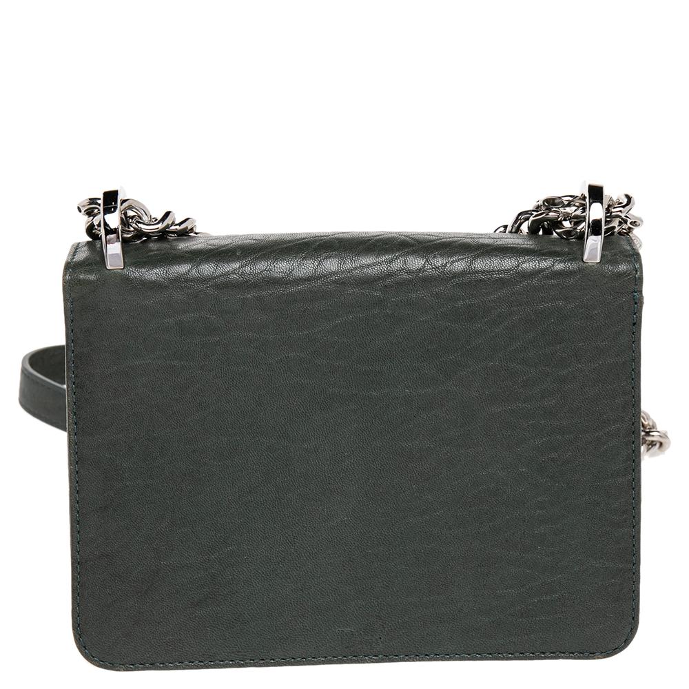 This Diorama Club shoulder bag has been crafted from green leather and detailed with embellishments on the exterior. The crest closure on the flap secures a leather interior, and a shoulder chain is provided for you to carry it. You will surely love