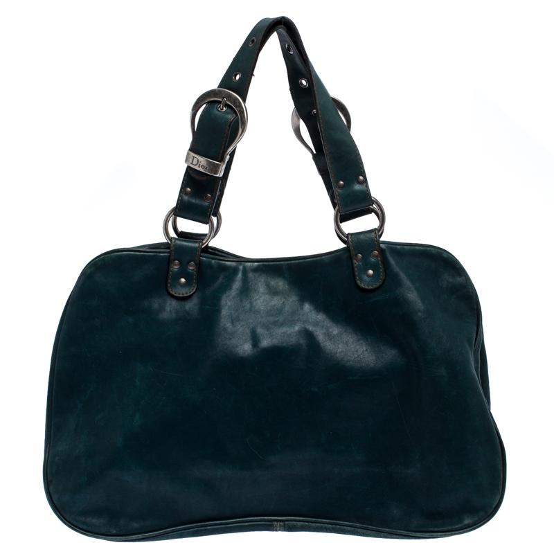 From the house of Dior, this Gaucho Double Saddle bag is an excellent blend of elegance and style. It comes in a green color that is perfect for making a statement. The bag is crafted from quality leather and features a chunky buckle, medallion, a
