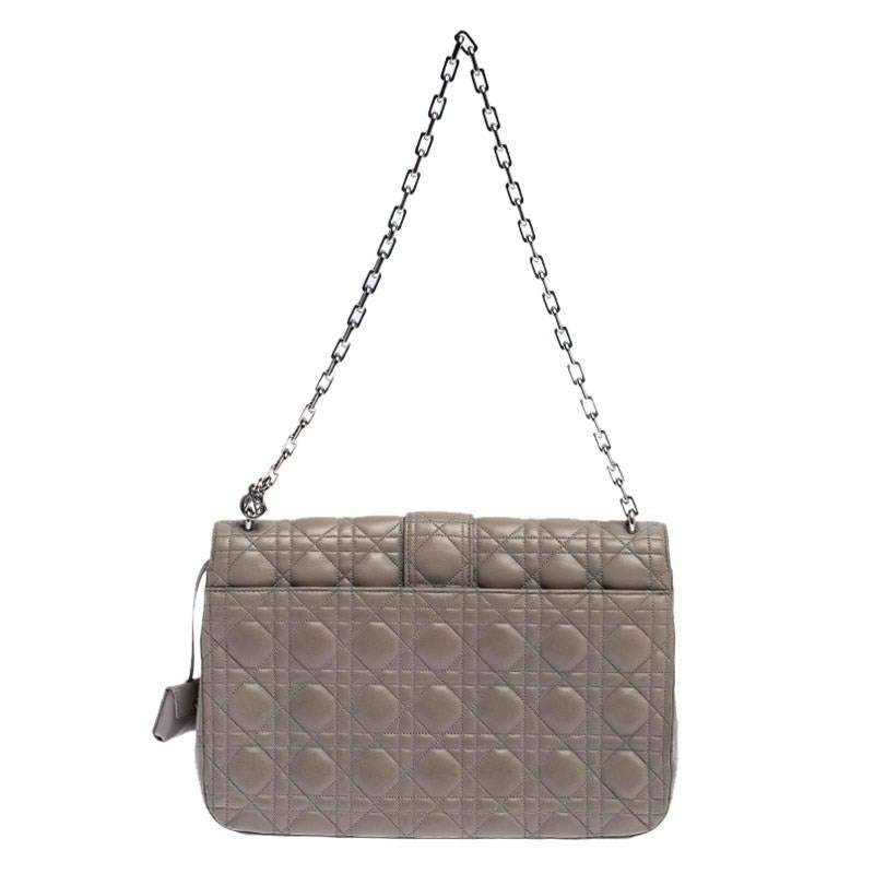Flap bags like this Miss Dior will never go out of style. Crafted from leather, this Dior flap bag features a grey Cannage exterior and a chain strap. The front flap has a Dior lock that opens to a leather-lined interior with enough space to keep