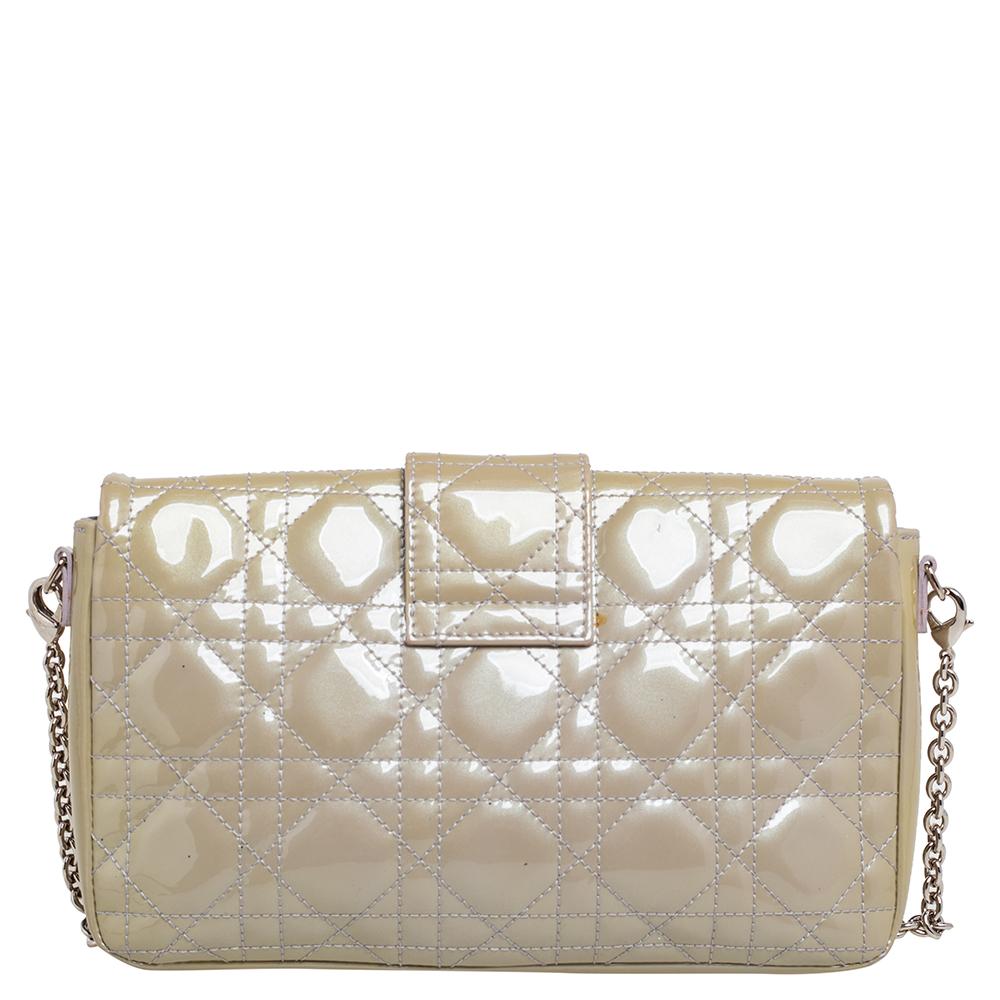 This stunning Miss Dior Promenade pouch is a compact version of the Miss Dior bag. Dazzling in a gorgeous grey shade, the bag is crafted from patent leather and features the signature Cannage pattern on the exterior, a detachable chain-link strap