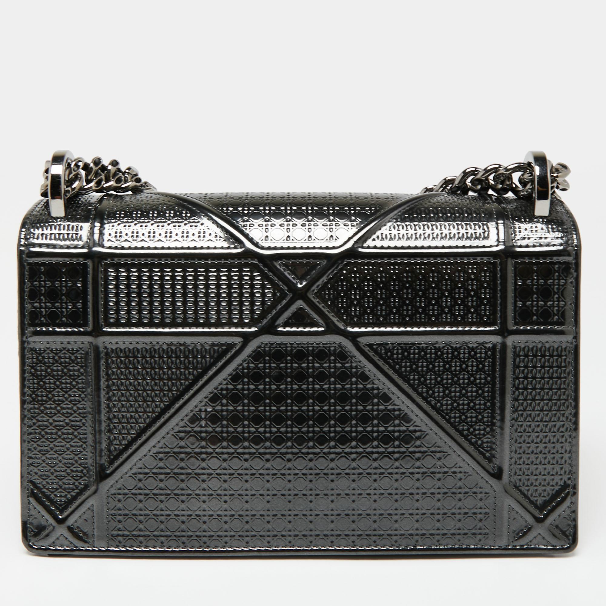 This Diorama bag is simply breathtaking! From its structured shape to its artistic craftsmanship, the bag sweeps us off our feet. It has been crafted from grey patent leather and is covered in the brand's signature Cannage pattern. The magnetic
