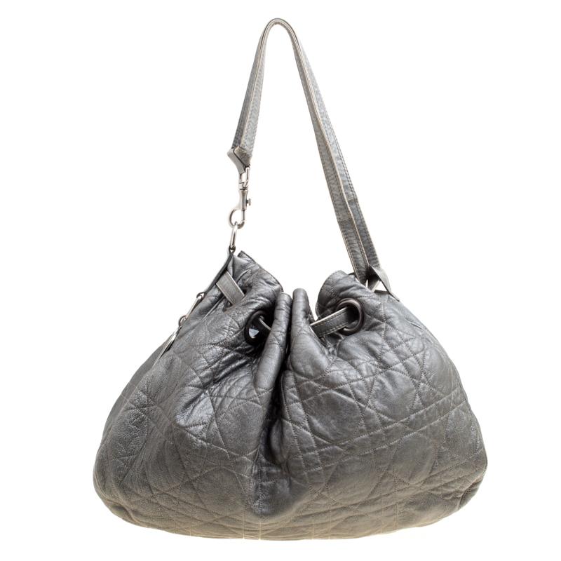 This stylish hobo from Dior has been crafted from grey leather and styled with their signature cannage pattern. The bag features a shoulder strap, a D cutout charm and a drawstring closure. The insides are fabric lined and spacious enough to hold